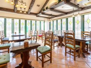 雫石町にある雫石リゾートホテルの木製のテーブルと椅子、窓のあるレストラン