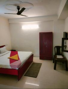 a bedroom with a bed and a chair and a ceiling at SMILEY SPACE HOTEL in Noida