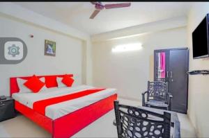a bedroom with a red bed and a television at SMILEY SPACE HOTEL in Noida