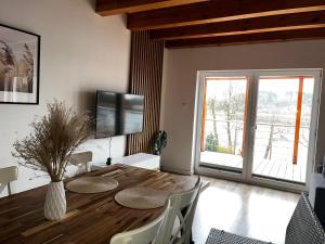 a dining room with a wooden table and a television at Wakacyjny Hartowiec 2 in Grodziczno