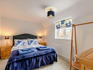 a bedroom with a bed with blue sheets and a window at 2 Bed in Holt 72898 in Holt