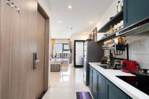 uma cozinha com armários azuis e um frigorífico em Shi House - Studios Toà S503 Vinhomes Grand Park Q9 em Long Bình