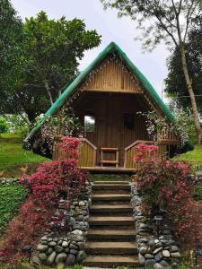 a small house with a staircase leading up to it at Bamboo Huts, Glamping, and Tent Camping at Humming Farm in Bagabag