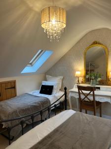 a bedroom with two beds and a mirror and a desk at Highcroft House in Corsham