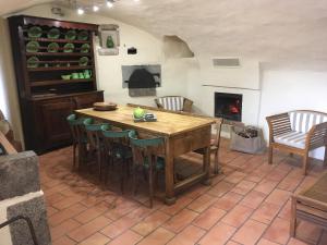 a kitchen with a table and chairs and a fireplace at Roulottes et Cabanes de Saint Cerice in Vogüé