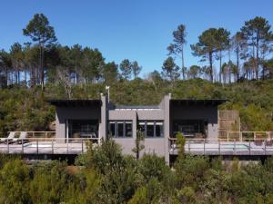 a house on a bridge with trees in the background at Cliffside Suites in Plettenberg Bay