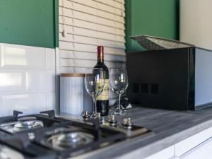 普利登堡灣的住宿－Cliffside Suites，炉子上放一瓶葡萄酒和两杯酒