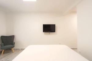 - une chambre blanche avec un lit et une chaise dans l'établissement Cozy modern apartment White Serenity, à Athènes