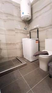 La salle de bains est pourvue de toilettes, d'un lavabo et d'une lumière. dans l'établissement Cozy modern apartment White Serenity, à Athènes