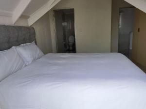 a large white bed in a small room at Beautiful apartment behind Illanga Mall in Mataffin