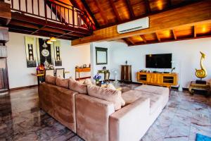 a living room with a couch and a television at Sandalwood Luxury Villa Resort in Lamai