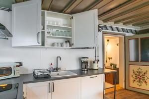 una cocina con armarios blancos y fregadero en Black Forest Moments inkl. Sauna für 8 Personen, en Hüfingen