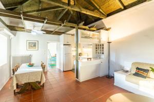eine Küche und ein Wohnzimmer mit einem Tisch und einem Esszimmer in der Unterkunft Elaion Hideaway - Uncover Petalidi's Secrets in Karpofóra