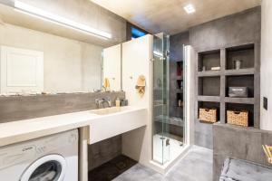 y baño con lavadora y ducha. en Elaion Hideaway - Uncover Petalidi's Secrets, en Karpofóra
