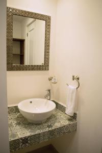 y baño con lavabo y espejo. en Hotel La Estación, en San Miguel de Allende