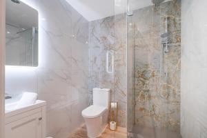 a white bathroom with a toilet and a shower at The Penthouse Collection by EPIC in Liverpool