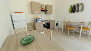 a kitchen and dining room with a table and chairs at B&B Bonomi in Torre Lapillo