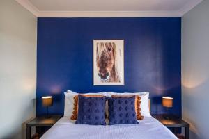 Un dormitorio azul con una cama con una foto de un caballo en Private Rural Solace at Saje Farm in Cooks Gap en Moolarben