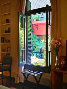- une fenêtre dans une chambre avec un vase de fleurs dans l'établissement BE Jardin Escondido By Coppola, à Buenos Aires