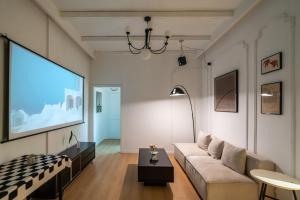 a living room with a couch and a large screen at Shanghai Downtown Yidu B&B - Near People's Square Metro Station in Shanghai