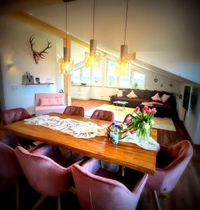 a room with a wooden table with pink chairs at 2023 NEU erbaute luxuriöse Ferienwohnung im Chaletcharakter mit Schlossblick in Halblech