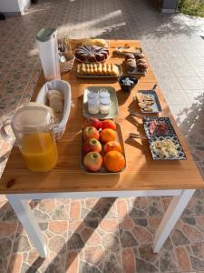 a wooden picnic table with food and drinks on it at Agriturismo Graziano e Barbara in Porto Conte