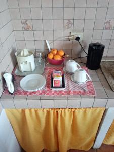 a kitchen counter with a table with a bowl of oranges at Casa Siciliana Altarbiah in Trabia