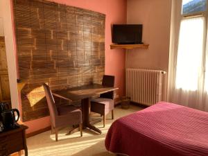 - une chambre avec un bureau et une chambre avec un lit dans l'établissement Hotel Victoria, à Saint-Pierre-de-Chartreuse