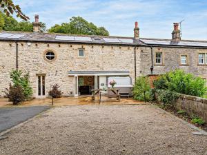 an old stone house with a wooden patio at 3 Bed in Settle 76650 in Stainforth