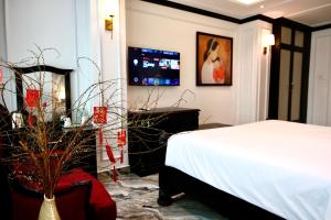 a bedroom with a bed and a tv on the wall at Nicecy Saigon Hotel in Ho Chi Minh City