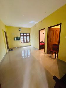 una sala de estar vacía con paredes amarillas y una puerta en Leisure familyvillas en Padinjarathara