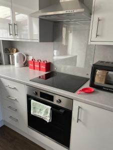 a kitchen with a stove top oven in a kitchen at Homely property close to Princess Royal hospital and Apley Wood in Wellington