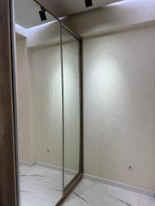 a glass shower in a room with at Cozy apartment - City Central in Tashkent