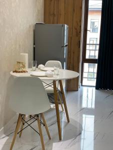 a white table with two chairs and a refrigerator at Cozy apartment - City Central in Tashkent