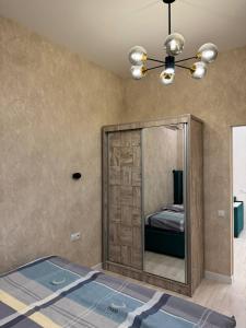 a mirror in a room with a bed and a ceiling fan at Cozy apartment - City Central in Tashkent