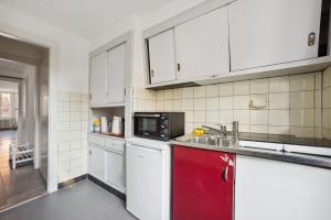 uma cozinha com armários brancos e um micro-ondas em Central Apartment in Laussane em Lausanne