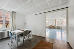 uma sala de jantar branca com uma mesa e cadeiras brancas em Central Apartment in Laussane em Lausanne