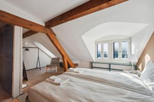een slaapkamer met een groot wit bed op een zolder bij Central Apartment in Laussane in Lausanne