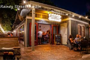 Un restaurante con gente sentada afuera por la noche. en The Forest, en Austin