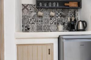 a kitchen with a stove and a tile wall at Ampelos Prokopios in Agios Prokopios
