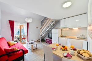 cocina y sala de estar con mesa y sofá rojo en Cina Apartments, en Cavtat