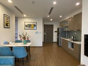 a kitchen and living room with a table and blue chairs at Serviced apartment Luxury in Vinhomes Westpoint in Hanoi