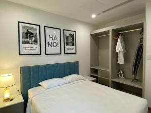 ein Schlafzimmer mit einem Bett und drei Bildern an der Wand in der Unterkunft Serviced apartment Luxury in Vinhomes Westpoint in Hanoi