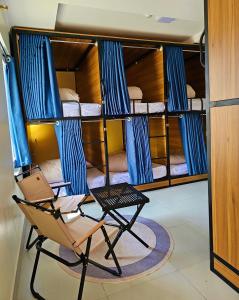 a chair in a room with bunk beds at Frontier Hostel & Tours in Dien Bien Phu
