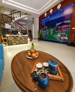 a wooden table with a bowl of fruit on it at Frontier Hostel & Tours in Dien Bien Phu