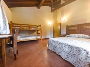 a bedroom with two beds and a desk and bunk beds at Amplia casa rural en entorno natural in Ziortza-Bolibar