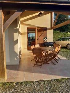 a patio with a wooden table and chairs on it at Villa*Piscine*Proche Sarlat in Proissans