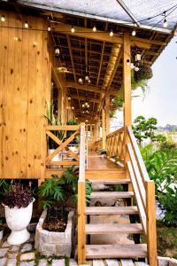una escalera de madera que conduce a una casa de madera en Dớt's Garden Homestay, en Da Lat