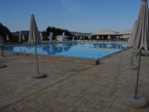 uma grande piscina com dois guarda-sóis em Maison de vacances dans un village de vacances à100 m. de la plage em Badesi