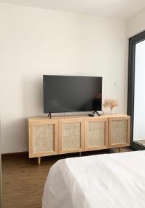 a flat screen tv sitting on top of a wooden cabinet at Serviced apartment Luxury in Vinhomes Westpoint in Hanoi